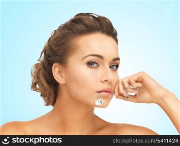 beautiful woman holding shiny diamond necklace in mouth