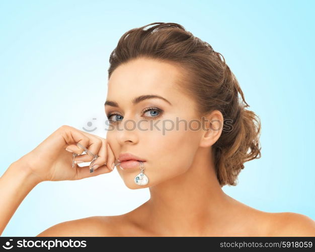 beautiful woman holding shiny diamond necklace in mouth. woman with diamond necklace