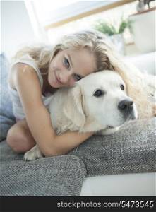 Beautiful woman hugging dog on sofa