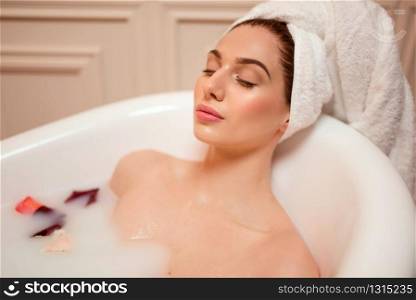 Beautiful woman in bathroom with rose petals.. Woman in bathroom with rose petals