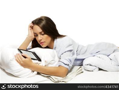 beautiful woman in bed reading ebook. beautiful woman in bed reading ebook on white background
