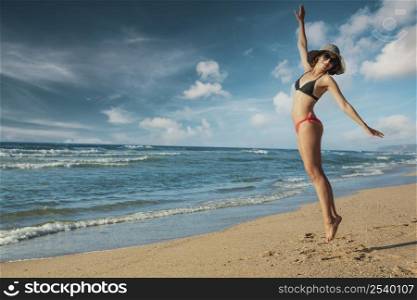 Beautiful woman in bikini jumping at the beach