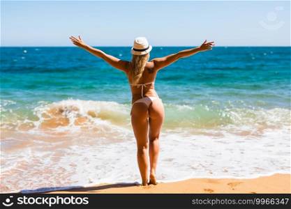 Beautiful woman in bikini. Young and sporty girl posing on a beach at summer.. Beautiful woman in white bikini. Young and sporty girl posing on a beach at summer.