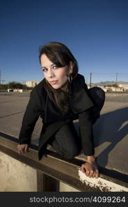 Beautiful woman in black trenchcoat in an urban setting