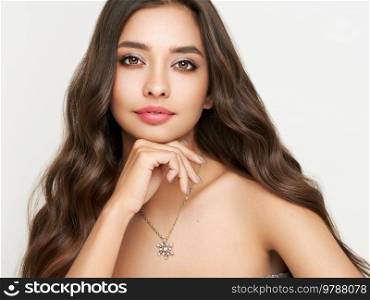 Beautiful woman in cocktail dress posing on white background. Beauty model with long curly hair. Christmas or New Year festivities. Jewelry and manicure