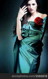 beautiful woman in green fabric with red rose