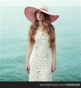 Beautiful woman in hat on the sea. Fashion photo