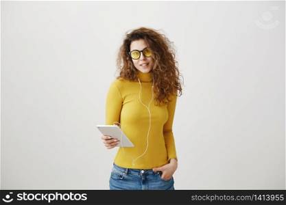 beautiful woman in headphones listening music and using digital tablet isolated on grey. beautiful woman in headphones listening music and using digital tablet isolated on grey.