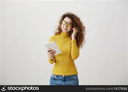 beautiful woman in headphones listening music and using digital tablet isolated on grey. beautiful woman in headphones listening music and using digital tablet isolated on grey.