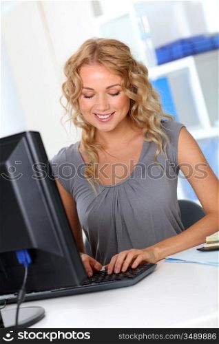 Beautiful woman in office working on desktop computer