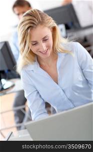Beautiful woman in office working on laptop computer