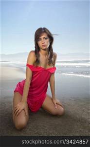 beautiful woman in red dress at sandy coast