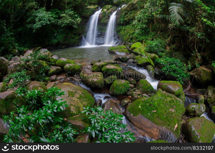 Beautiful woman in red dress in front of the Sapan Waterfall, Khun Nan National Park, Boklua District, Nan Province, Thailand.. Sapan Waterfall.