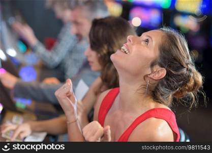 beautiful woman in red dress playing slot machine and winning