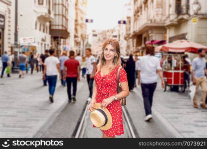 Beautiful woman in red dress stands at Istiklal street,a popular location in Beyoglu district,Istanbul,Turkey. Beautiful woman in red dress stands at Istiklal street