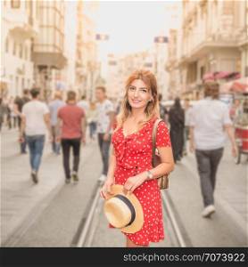 Beautiful woman in red dress stands at Istiklal street,a popular location in Beyoglu district,Istanbul,Turkey. Beautiful woman in red dress stands at Istiklal street