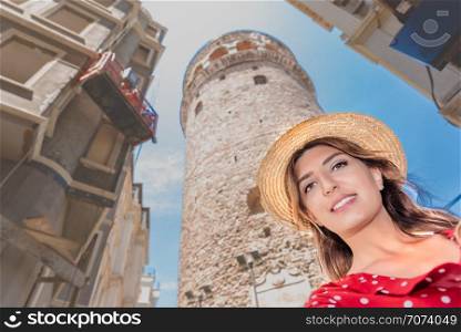 Beautiful woman in red dress takes selfie with background view of landmark Galata tower in Beyoglu,Istanbul,Turkey. Beautiful woman in red dress sits on a ferry Istanbul on background.