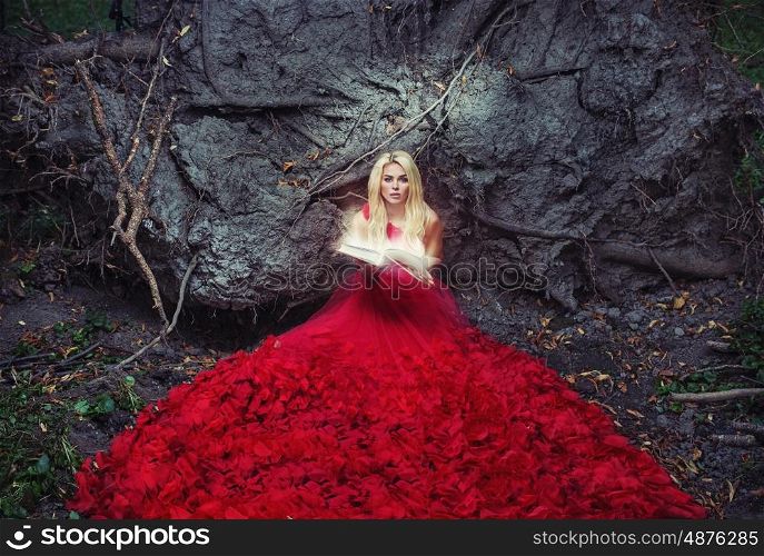 Beautiful woman in red gown reading an ancient book
