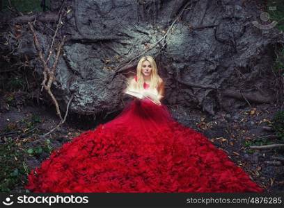 Beautiful woman in red gown reading an ancient book