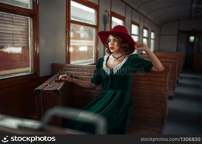 Beautiful woman in retro train, old wagon interior. Railroad voyage. Vintage journey. Beautiful woman in retro train, old wagon interior