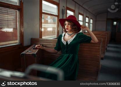 Beautiful woman in retro train, old wagon interior. Railroad voyage. Vintage journey. Beautiful woman in retro train, old wagon interior