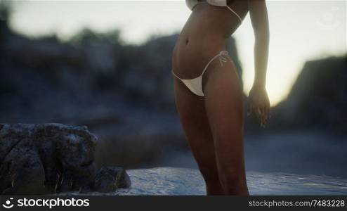 beautiful woman in sexy bikini near the rocks at sea. Beautiful Woman in Sexy Bikini near the Rocks