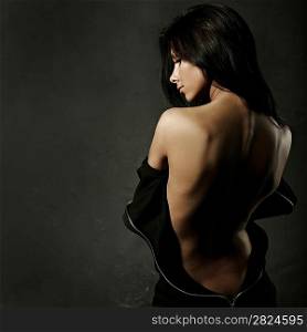 beautiful woman in sexy evening dress against dark background