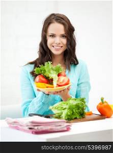 beautiful woman in the kitchen cutting vegetables