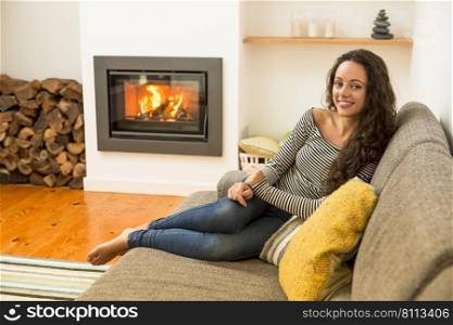 Beautiful woman in the living room at the warmth of the fireplace