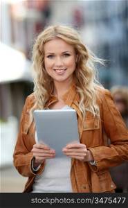 Beautiful woman in town using electronic tablet