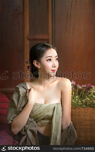 beautiful woman in traditional asian dresses sitting near bouquet of flowers. beautiful woman in traditional asian dresses