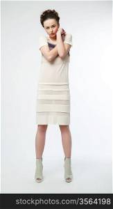 Beautiful woman in white contemporary dress. Studio shot