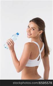Beautiful woman in white sport lingerie with bottle of water over white. Woman with bottle of water over white