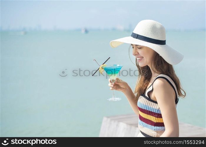 Beautiful woman is drinking ice summer drink in the beach, summer concept
