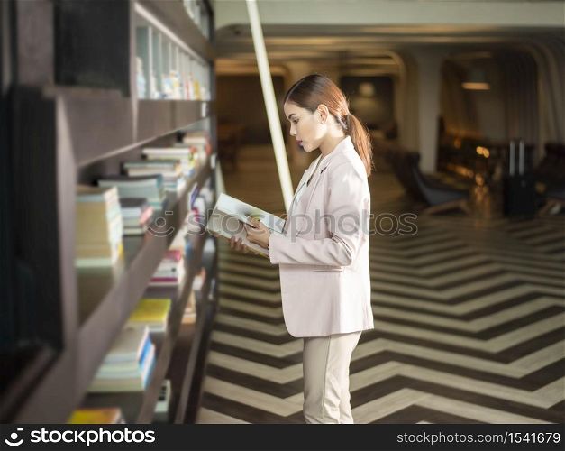 Beautiful woman is reading books in library