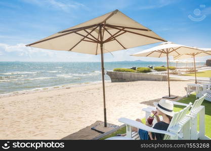 Beautiful woman is relaxing on the beach , under umbrella