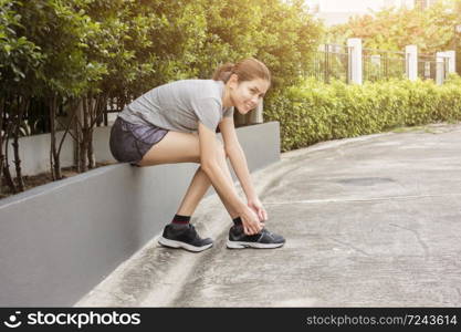 beautiful woman is tying her shoes