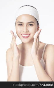 Beautiful woman is washing her face on white background