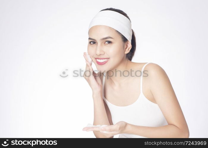 Beautiful woman is washing her face on white background