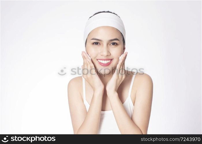 Beautiful woman is washing her face on white background