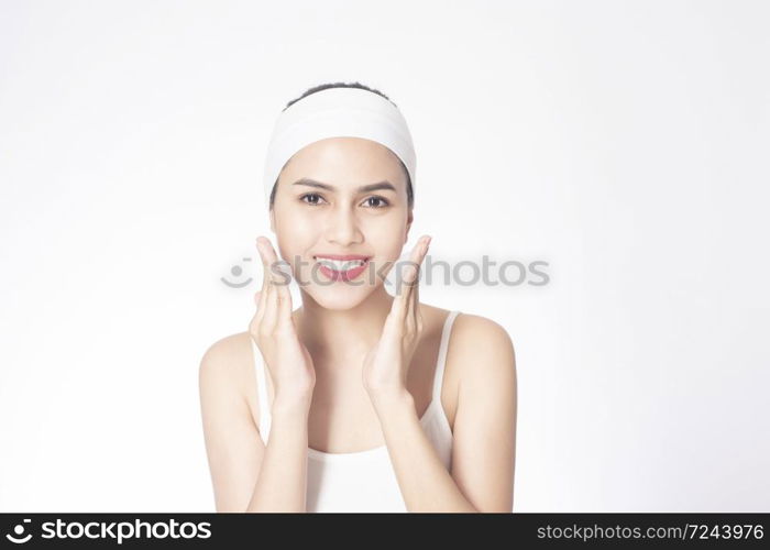 Beautiful woman is washing her face on white background