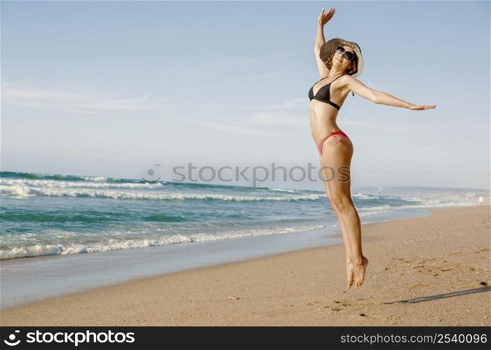 Beautiful woman jumping on the beach