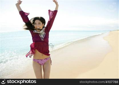 beautiful woman jumping on the beach, purple bikini