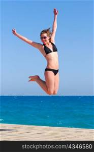 beautiful woman jumps near the sea