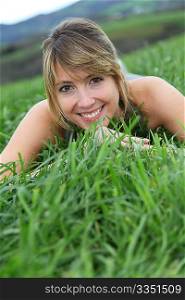 Beautiful woman laying down green field
