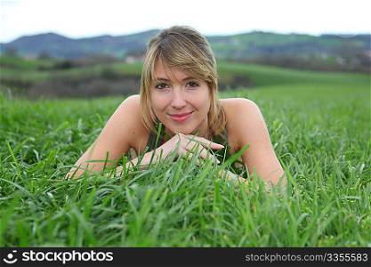 Beautiful woman laying down green field