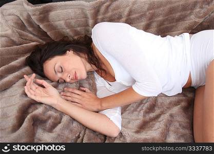 Beautiful woman laying in soft blanket