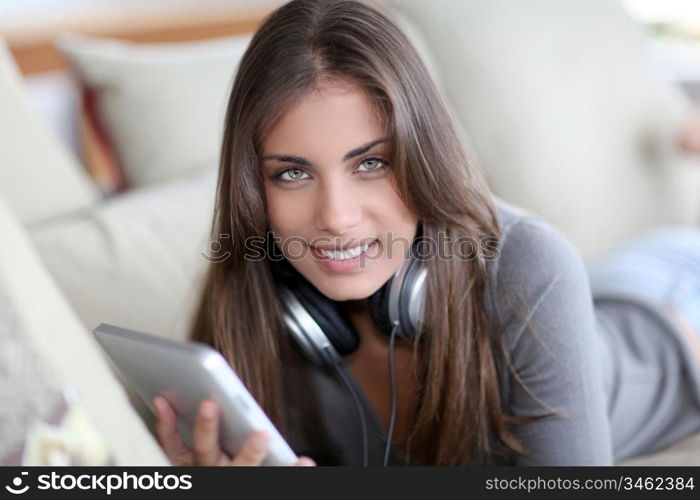 Beautiful woman laying on sofa with touchpad