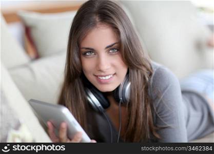 Beautiful woman laying on sofa with touchpad