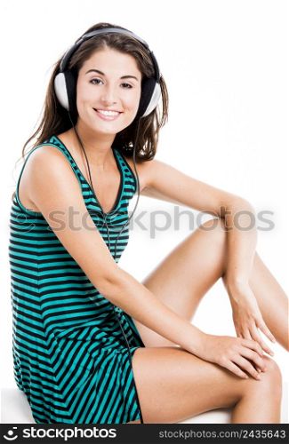 Beautiful woman listen music with headphones, isolated in white